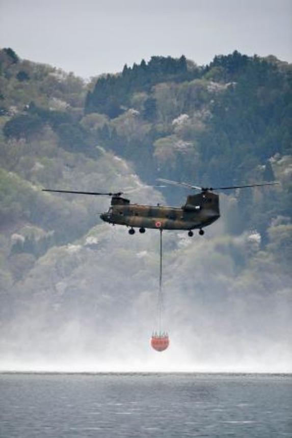 　山林火災の消火活動のため、海水をくみ上げるヘリコプター＝２７日午前、岩手県大槌町
