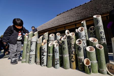 　阪神大震災の追悼行事に向け、文字が書き入れられた竹灯籠＝１０日午前、神戸市北区の「あいな里山公園」