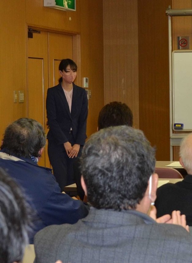 自民党多治見市支部の役員らに拍手で迎えられる今井瑠々氏＝多治見市新町、市産業文化センター