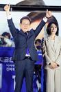 　韓国大統領選で当選を確実にし、支持者の前で両手を上げる「共に民主党」の李在明前代表＝４日未明、ソウルの国会前（共同）