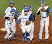 　引退試合前、チームメートに囲まれながら守備練習に向かう日本ハム・中島（手前中央）＝エスコンフィールド