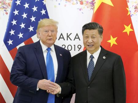 　２０１９年６月、米中首脳会談を前に握手するトランプ米大統領（左）と中国の習近平国家主席＝大阪市（ロイター＝共同）