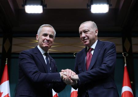 　２２日、トルコ・アンカラでの記者会見で握手するカナダのカーニー首相（左）とトルコのエルドアン大統領（ロイター＝共同）