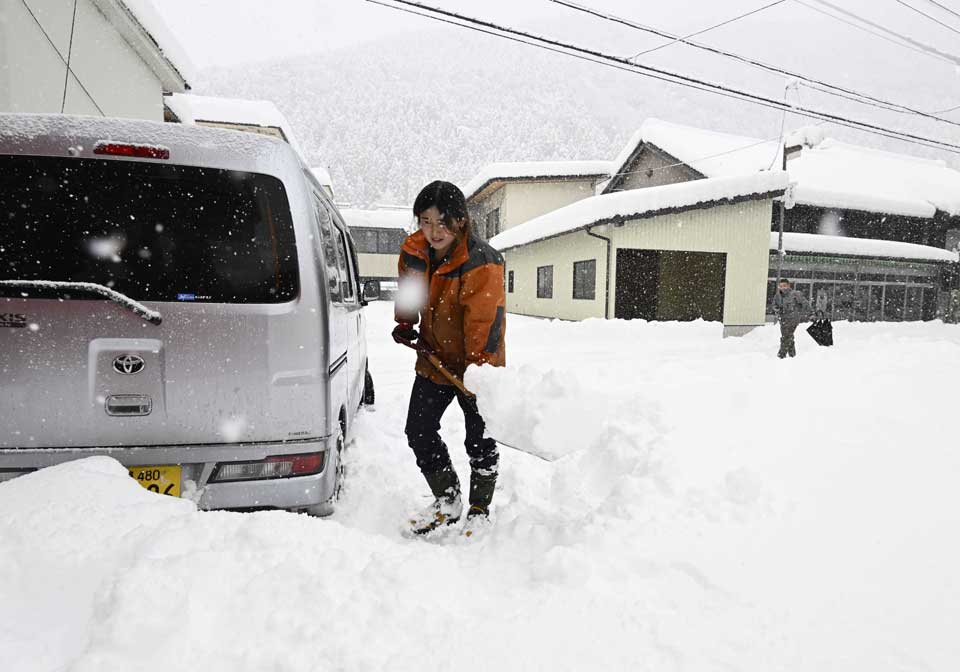 ６０センチ以上積もった雪をかく住民＝５日午前８時２６分、本巣市根尾市場