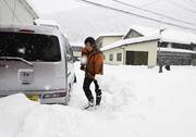 ６０センチ以上積もった雪をかく住民＝５日午前８時２６分、本巣市根尾市場