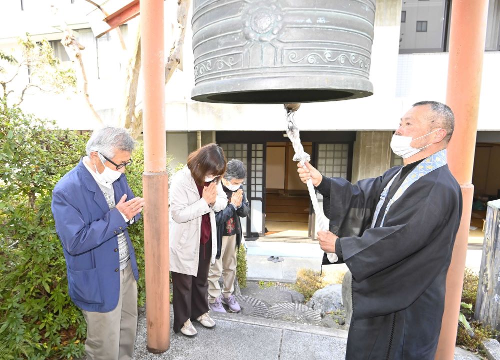 東日本大震災の犠牲者を追悼し、鐘を突く松田明宗前住職＝岐阜市神田町、円徳寺