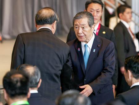 　中国のナショナルデーに出席し、何立峰副首相（左）と握手する自民党の森山幹事長＝１１日午前、大阪市此花区の夢洲（代表撮影）