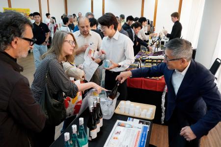 　新潟県の日本酒の試飲コーナーに集まる来場者＝２２日、ブラジル・サンパウロ（共同）