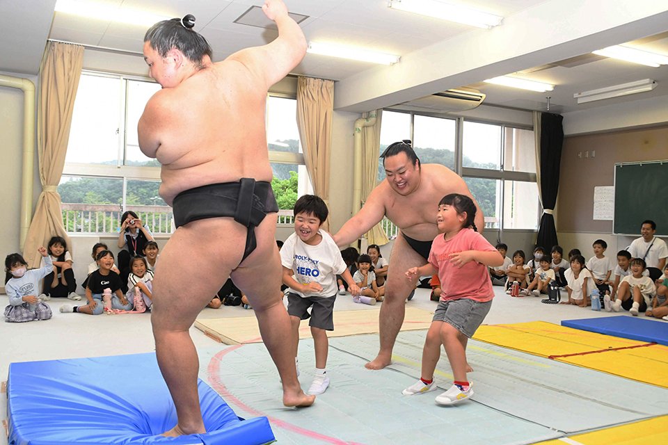 力士をマットの外へ押し出す児童ら＝御嵩町中、上之郷小学校