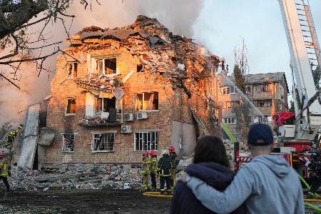 　ロシア軍の攻撃により破壊された建物で活動する消防関係者＝２８日、ウクライナの首都キーウ（ＡＰ＝共同）