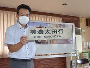 行き先を表示するサインボードを手にする社員＝関市元重町、元重公民館