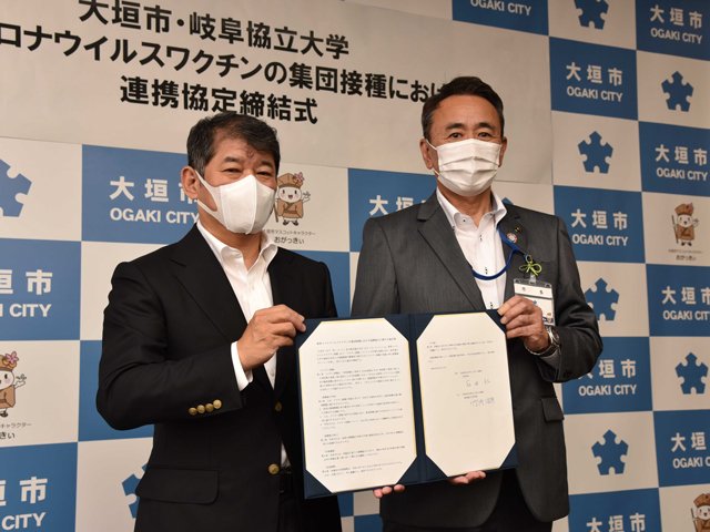 ワクチン集団接種で連携する協定書を手にする岐阜協立大の竹内治彦学長（左）と石田仁市長＝大垣市役所