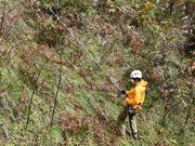 ロープを伝って斜面を下りる隊員＝高山市岩井町、国立乗鞍青少年交流の家