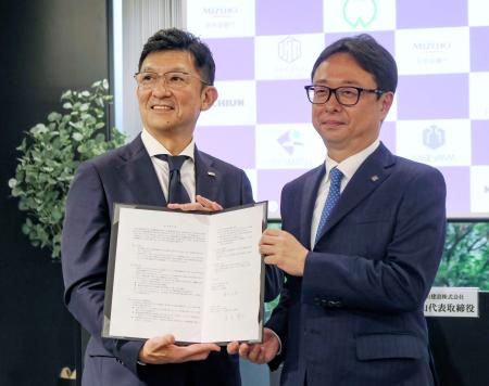 　新会社の社長に就く陰山正弘氏（右）と、みずほ銀行の足立龍生共同部門長＝２３日午後、東京都千代田区