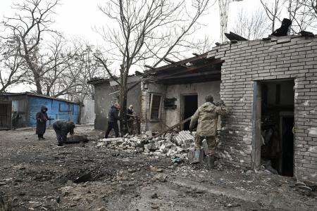 　６日、ウクライナ南部ザポリージャで、ロシア軍の攻撃後のがれきを片付けるボランティアら（ロイター＝共同）