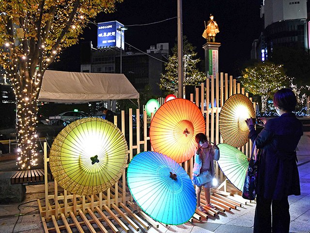 和の雰囲気を醸し出す岐阜和傘のイルミネーション＝１９日午後５時３０分、岐阜市橋本町、ＪＲ岐阜駅北口駅前広場
