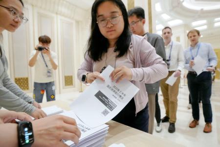 　中国国家統計局のＧＤＰ速報値などに関する資料を受け取る報道関係者ら＝１５日、北京（共同）