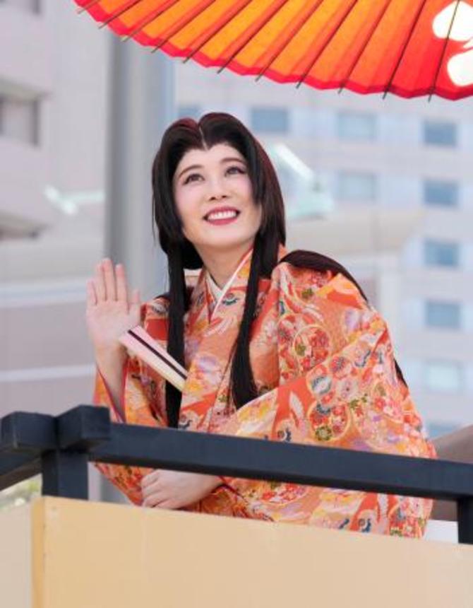 　「百万石行列」で観客に手を振る、お松の方役の北乃きいさん＝７日午後、金沢市