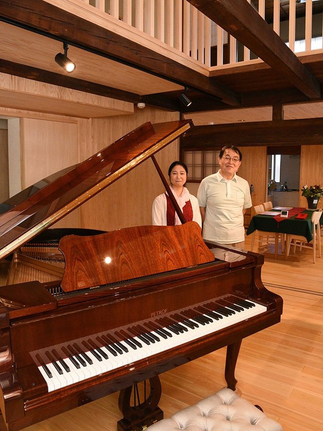 ピアノなど楽器演奏も楽しめる民泊施設「縁音」を紹介する経営者の石井さん夫婦＝大垣市赤坂町