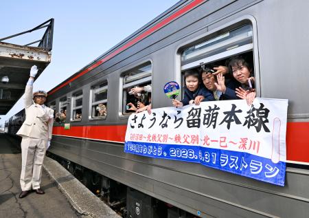 　ＪＲ北海道の留萌線が運行最終日を迎え、石狩沼田駅を発車した列車から手を振る乗客＝３１日午前、北海道沼田町