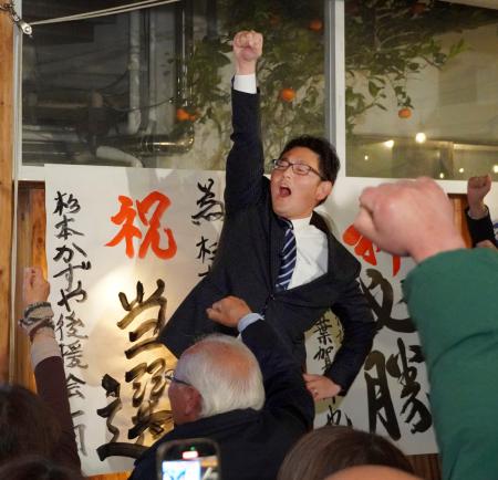 　静岡県伊東市長選で当選を決め、支持者らと拳を突き上げる杉本憲也氏＝１４日深夜、伊東市
