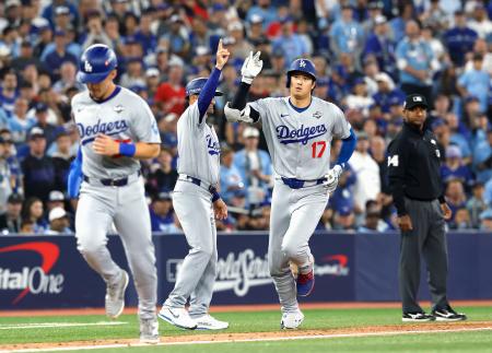 　ブルージェイズ戦の７回、２ランを放ち三塁コーチとタッチを交わすドジャース・大谷（右）＝トロント（共同）