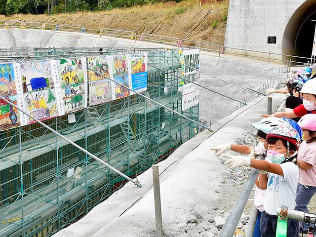 中部縦貫道工事現場に飾られた自分たちの絵を見学する園児＝高山市上野町