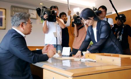 　回答書を中島弘道議長（左）に提出する、静岡県伊東市の田久保真紀市長＝８日午後、伊東市役所