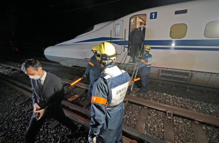 　ＪＲ東海の訓練で、停止した新幹線の車両から線路に降りる乗客役＝２４日未明、静岡市