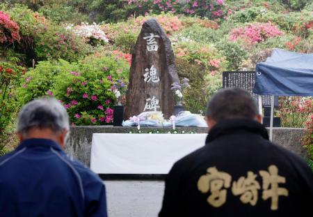 　「畜魂碑」の前で黙とうする参列者＝２０日午前、宮崎県都農町