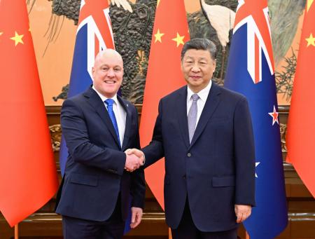 　握手するニュージーランドのラクソン首相（左）と中国の習近平国家主席＝２０日、北京の人民大会堂（新華社＝共同）