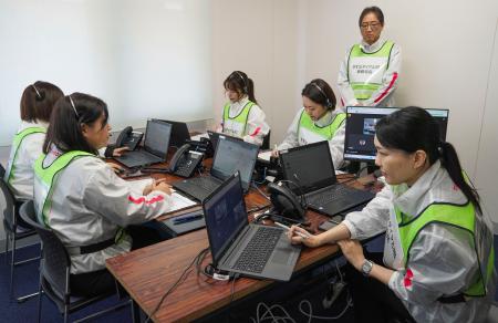 　大規模災害時の安否不明者に関する電話対応訓練で、手順を確認する民間企業のスタッフ＝１４日午前１０時１１分、徳島県美馬市