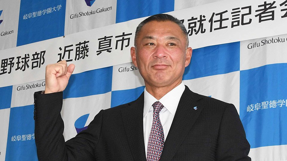 就任会見でポーズをとる岐阜聖徳大の近藤真市監督＝同大羽島キャンパス