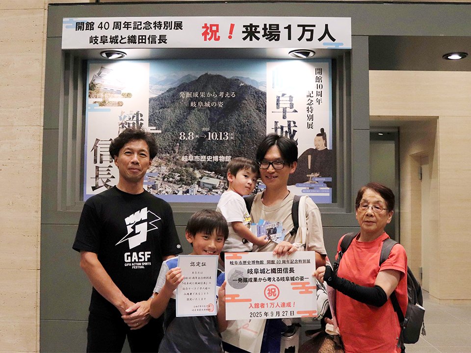 １万人目の来場者となった水野良介さん（右から２人目）一家＝岐阜市大宮町、市歴史博物館