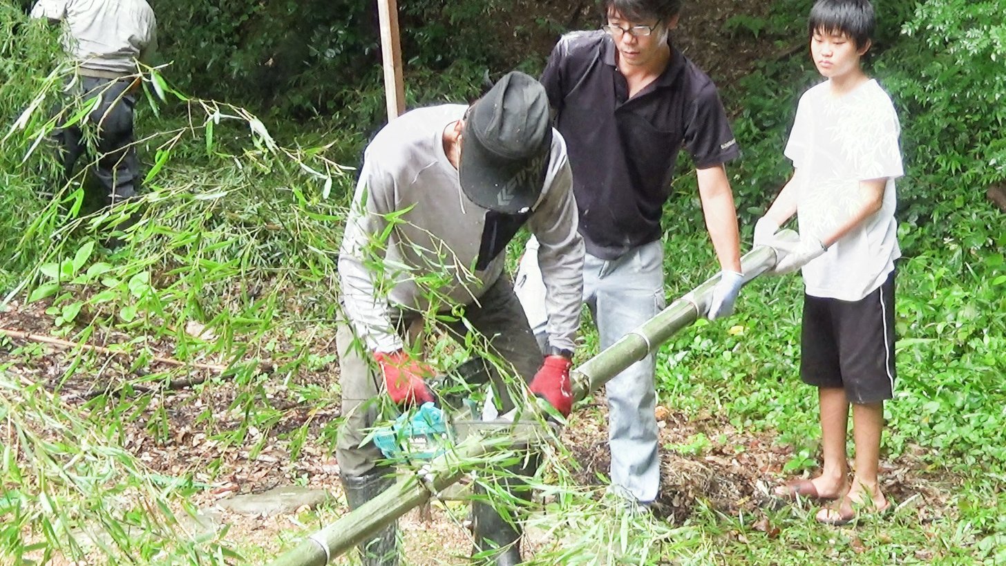 竹チップに再生するため竹を伐採するスタッフと子どもたち＝本巣市文殊、お山のおうち