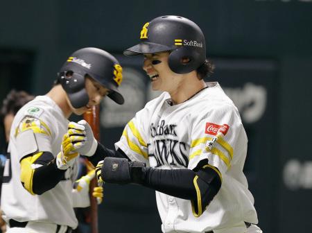 　１回、先頭打者本塁打を放ち周東（左）に迎えられるソフトバンク・正木＝みずほペイペイドーム