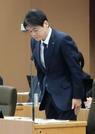 　横浜市議会総務委員会で謝罪する山中竹春市長＝１３日午前