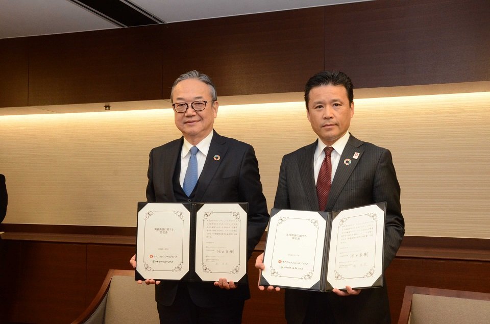 協定書に署名した十六フィナンシャルグループの池田直樹社長（左）とりそなホールディングスの南昌宏社長＝７日午後３時６分、名古屋市中区、十六銀行名古屋ビル