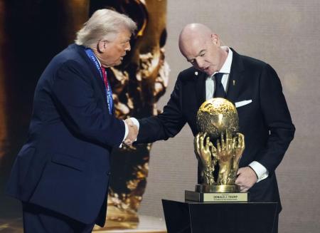 　２０２５年１２月、サッカーＷ杯北中米３カ国大会の組み合わせ抽選会で、トランプ米大統領（左）に「ＦＩＦＡ平和賞」を授与するインファンティノ会長＝米ワシントン（共同）