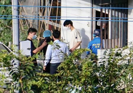 　任意同行に応じるダム・ズイ・カン容疑者（左から４人目）＝２７日、佐賀県伊万里市