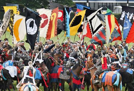 　相馬野馬追の神旗争奪戦で、打ち上げられて舞い降りる旗を奪い合う騎馬武者＝２４日午後、福島県南相馬市