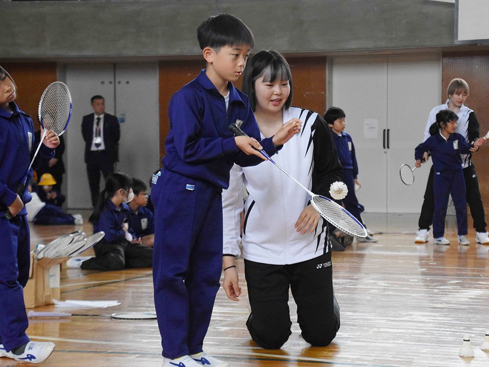 平本梨々菜選手（中央）に教わりながら的当てに挑戦する児童＝池田町八幡、八幡小学校