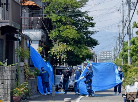 　「包丁で切られた」と通報があった兵庫県西宮市の住宅付近を調べる兵庫県警の捜査員＝２６日午後０時３２分