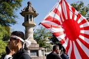 　１５日、靖国神社（東京・九段北）で旭日旗を掲げる人。（ロイター＝共同）
