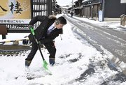雪かきをする旅館関係者＝８日午前８時１３分、岐阜市湊町