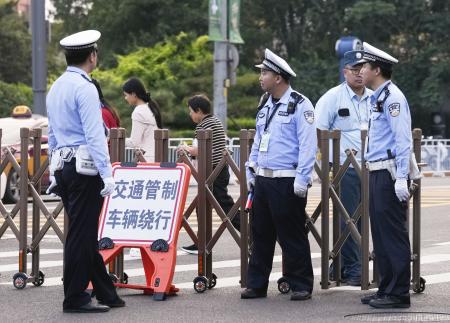 　北京市内で車両の通行を規制する警察官＝１６日（共同）