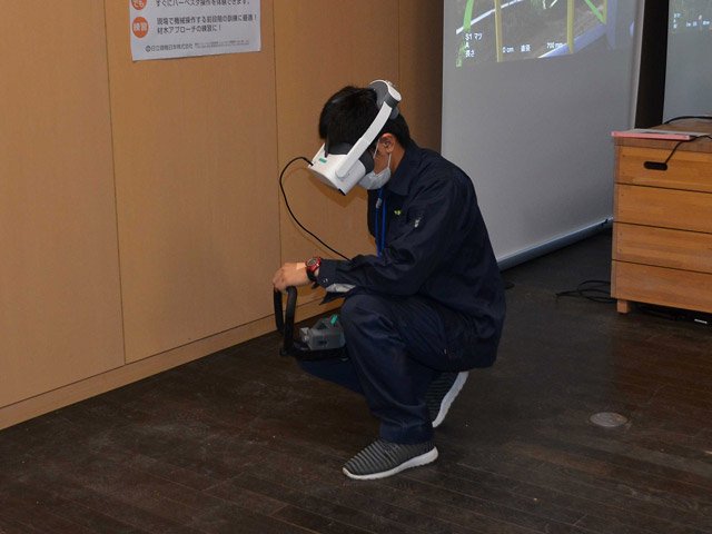 専用の装置を使ってチェーンソーの操作技術を体験する参加者＝美濃市曽代、県森林文化アカデミー