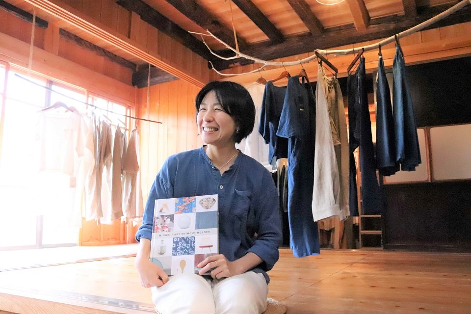 展覧会の図録を手に「海外で注目されてうれしい」と話す平野馨生里さん＝郡上市白鳥町、石徹白洋品店