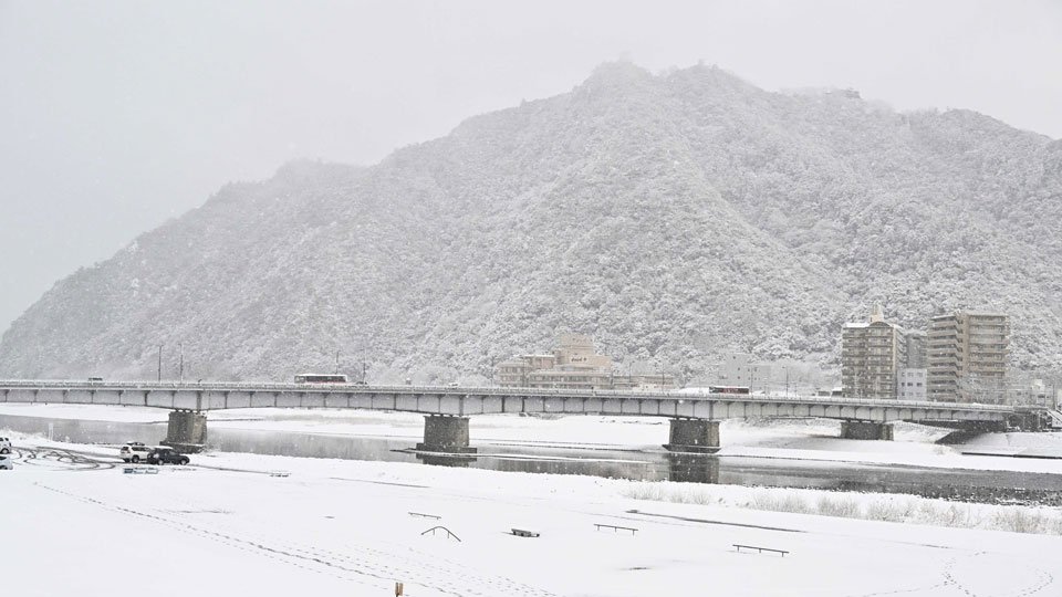 雪化粧した金華山。手前は長良橋＝８日午前８時２４分、岐阜市内