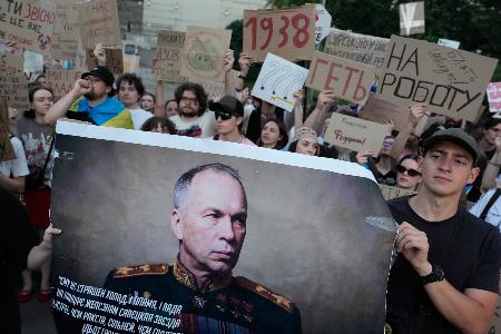 　抗議デモでウクライナのシルスキー軍総司令官の肖像を掲げる人＝１８日、キーウ（ＡＰ＝共同）